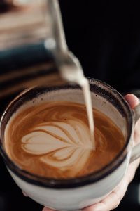 Home Professionele barista bereidt koffie met latte-art voor evenement of bedrijf